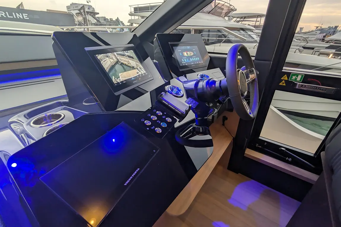 Modern boat dashboard featuring twin displays, steering wheel, controls, and ambient lighting, with 'VOLVO PENTA' branding visible.